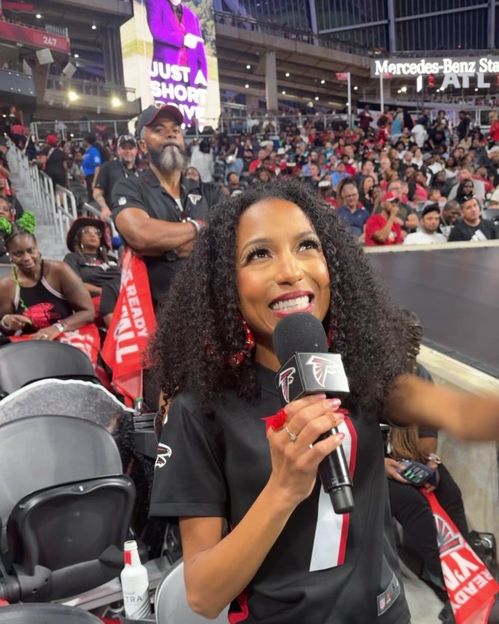 Chelsea on the mic in the stands at a packed Falcons game
